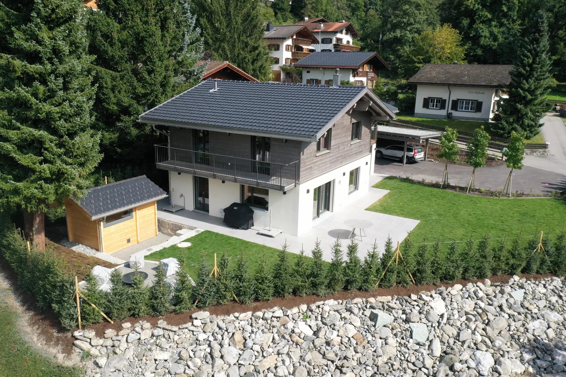 Einfamilienhaus mit Holzfassade und Natursteinmauer