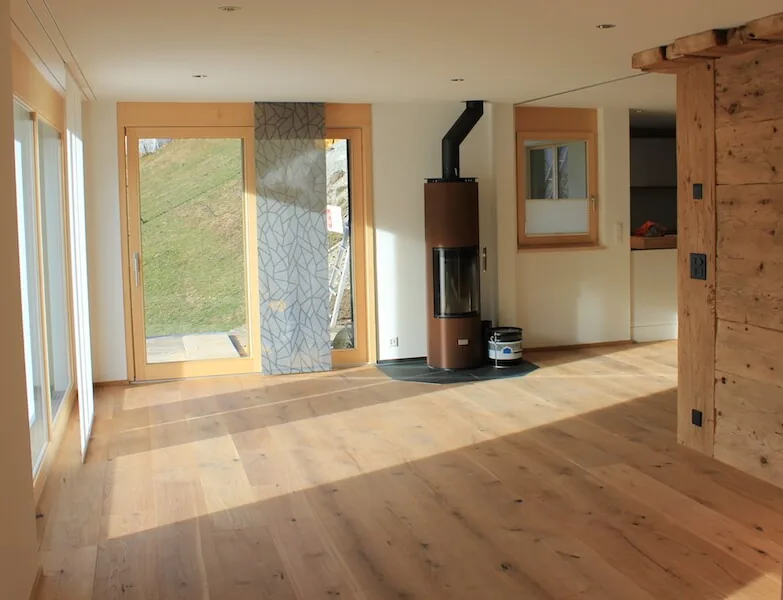 Wohnzimmer mit Holzwand und Ofen