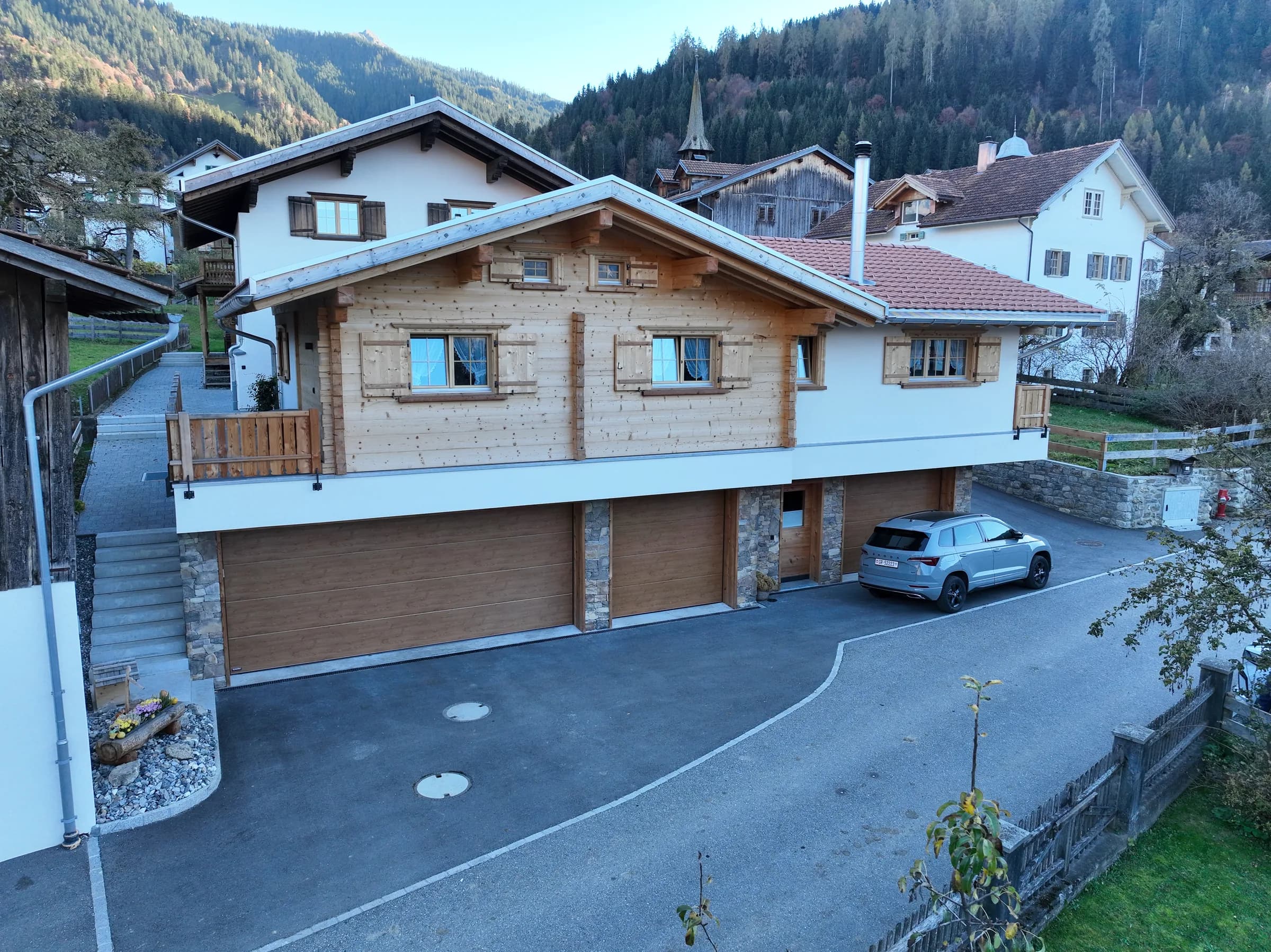 Wohnhaus mit Garagen im Sockel und Holzfassade